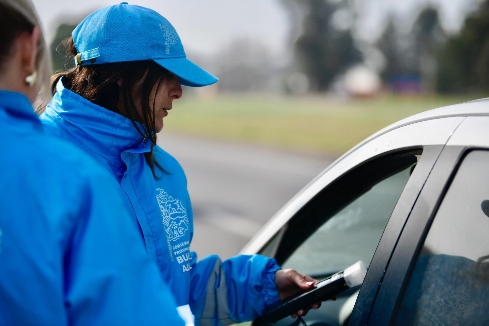 Una agente fiscalizadora de Seguridad Vial realiza un control de alcoholemia a un vehículo.