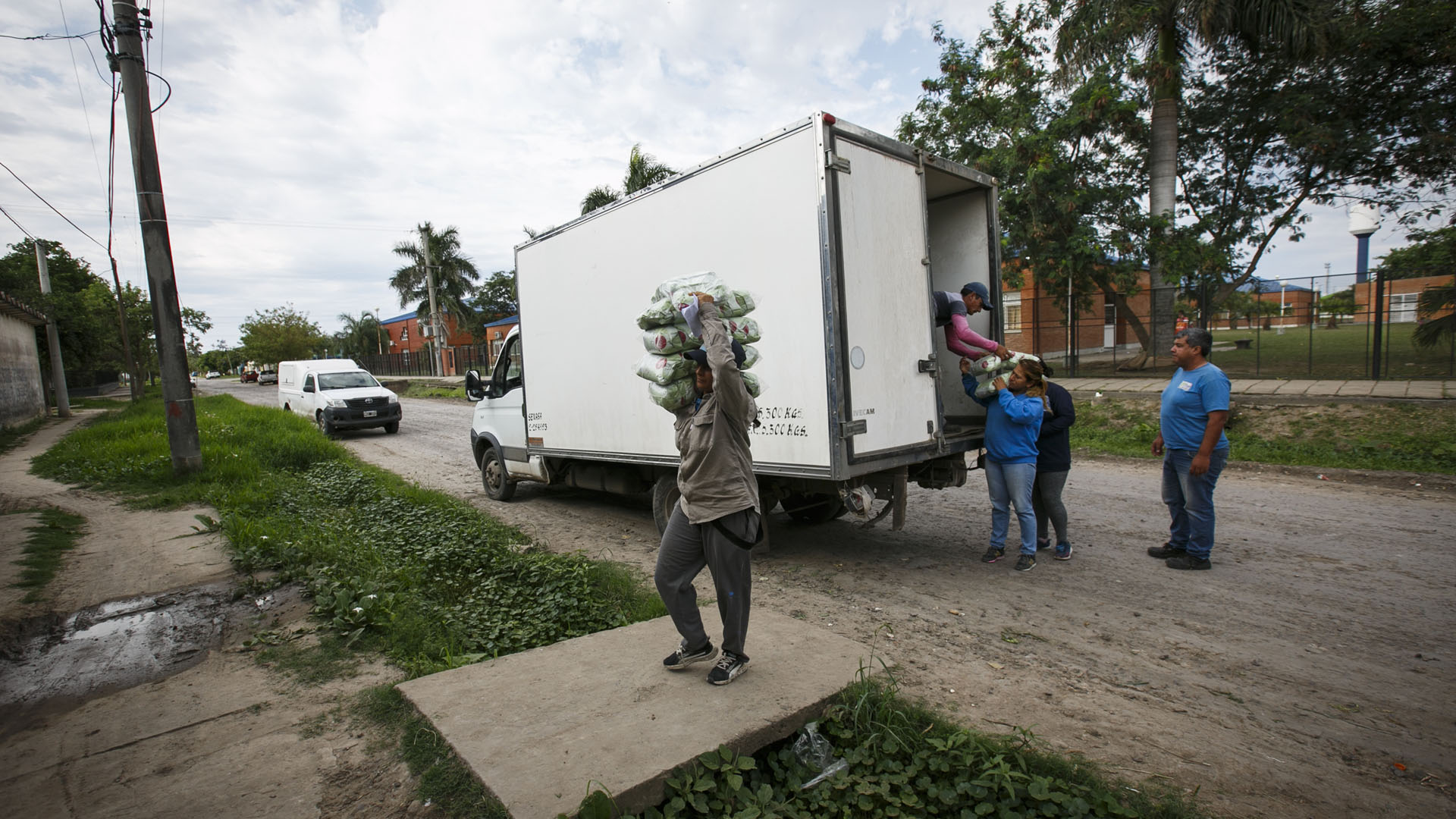 Hombre descargando una bolsa de alimento de un camión para brindar asistencia a las familias vulnerables,