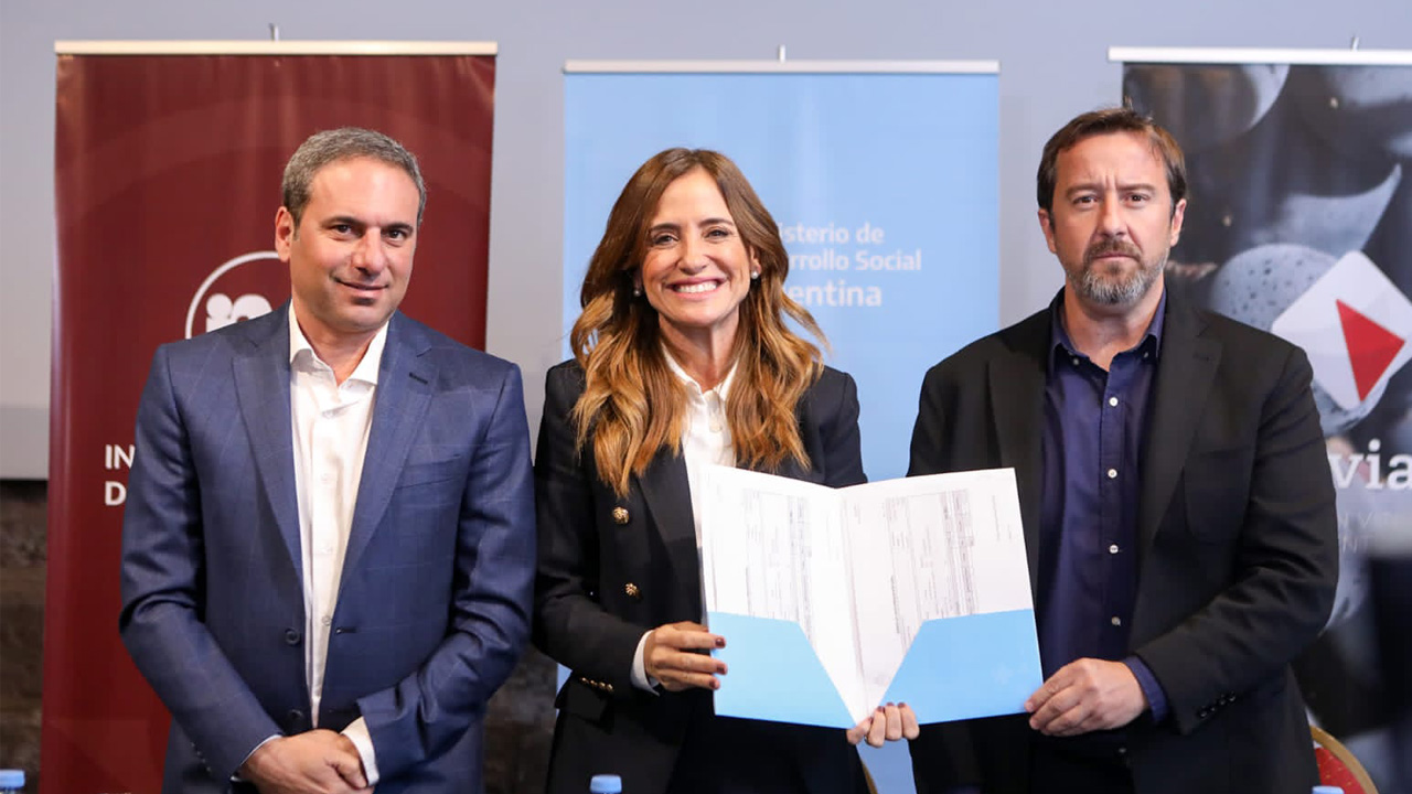 La ministra Victoria Tolosa Paz acompañada por presidente del Instituto Nacional de Vitivinicultura, Martín Hinojosa y por el titular de la Corporación Vitivinícola de Argentina, Mario González con una carpeta abierta en sus manos.