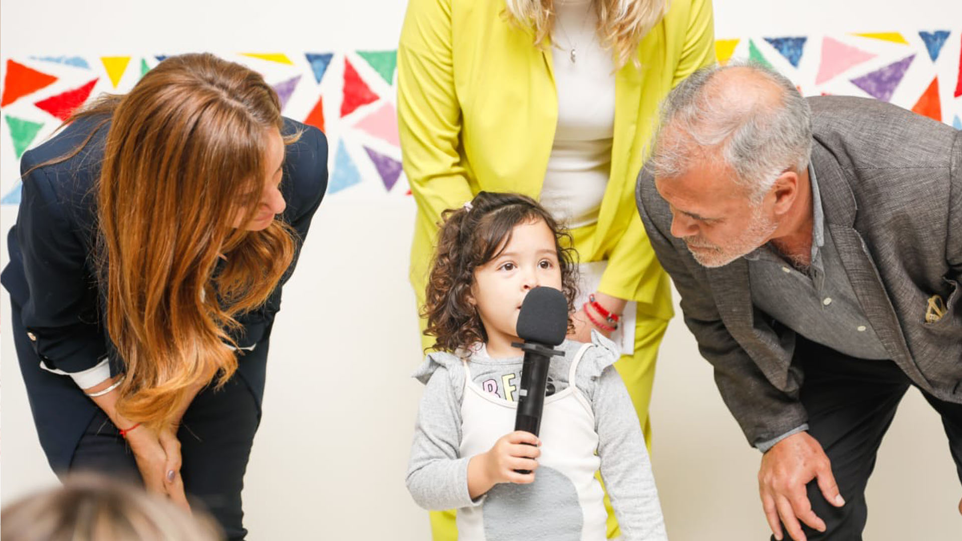 La ministra Tolosa Paz junto al Secretarío de Niñez, Adolescencia y Familia, Gabriel Lerner al lado de una niña pequeña con un micrófono en la mano.