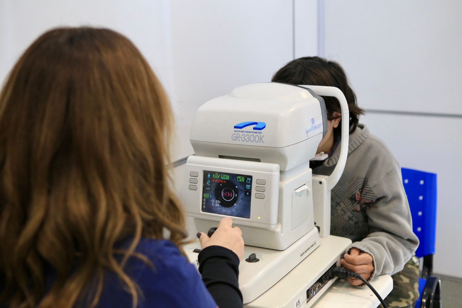 Un profesional de la salud se encuentra usando una máquina especializada para el control ocular.